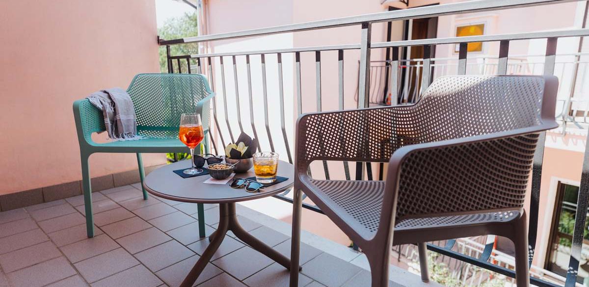 Balcone accogliente con sedie moderne, bevande rinfrescanti e atmosfera rilassante.